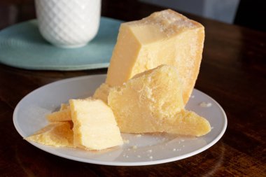 Bir tabakta İtalyan parmesan peyniri dilimi. Sabah Erken saatlerde masada yemek.