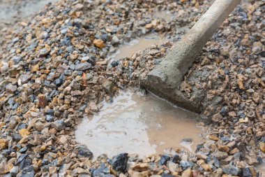 İnşaat teknisyenleri inşaat için çimento, taş ve kumu karıştırıyorlar..