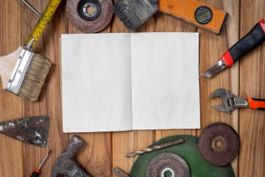 Ahşap zemine beyaz kağıt ve manuel araç yerleştirildi.