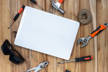 White paper and manual tool set on wooden floor.