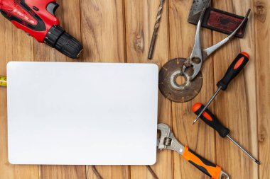 White paper and manual tool set on wooden floor.