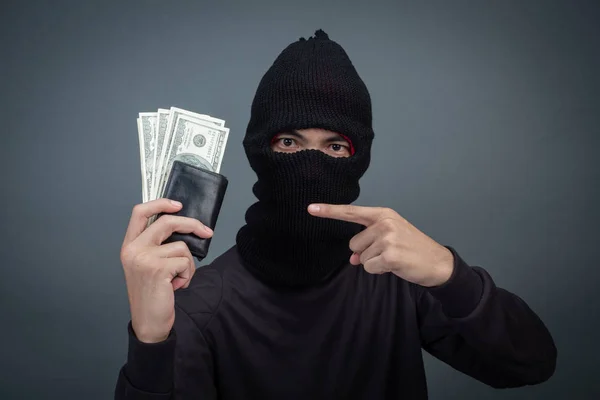 Thief wears a black hat with a stolen purse on a gray background.