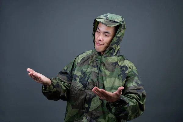 Young Man Wears Camouflage Raincoat Shows Different Gestures Gray Background — Foto de Stock