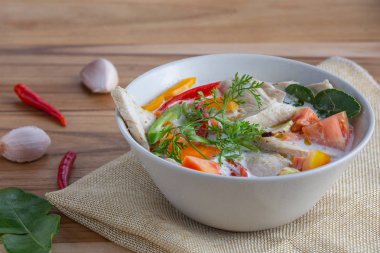 Tom Kha Kai ahşap bir masaya beyaz bir kupa koydu..