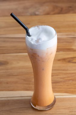 Tahta zemine yerleştirilmiş uzun bardakta buzlu çay..