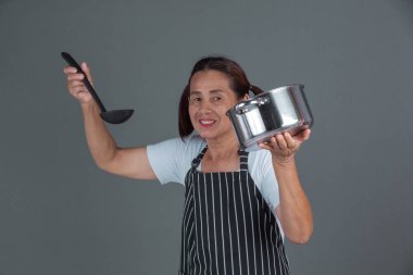 Elinde mutfak gereçleri olan yaşlı bir aşçı..