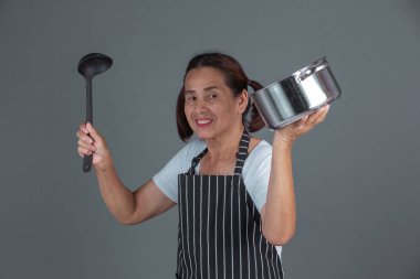 Elinde mutfak gereçleri olan yaşlı bir aşçı..