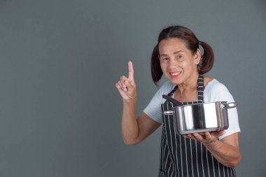 Elinde mutfak gereçleri olan yaşlı bir aşçı..