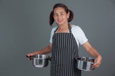 Elinde mutfak gereçleri olan yaşlı bir aşçı..