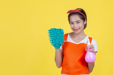 Temizlik konsepti. Sarı arka planda temizlik aleti olan güzel bir kadın..