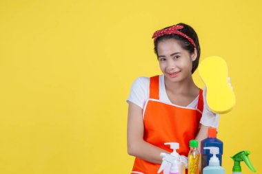 Cleaning concept. A beautiful woman with a cleaning device on a yellow background.