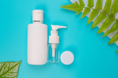 Mavi arka planda yatan kadın kozmetik ürünleri.