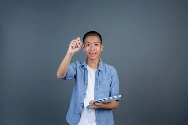 Niño Adolescente Con Una Camisa Azul Sosteniendo Libro Sobre Fondo — Foto de Stock