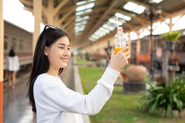 Kadınlar tren istasyonunda seyahat ederken mutlular. Turizm konsepti