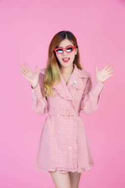 Moda kızı pembe arka planda el hareketleriyle süslenir..