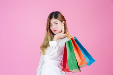 Güzel beyaz kız pembe bir arka planda bir alışveriş çantası, moda ve güzellik tutuyor..