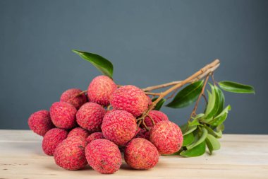 Kırmızı liçi meyvesi ahşap zeminde bir sepete konur..