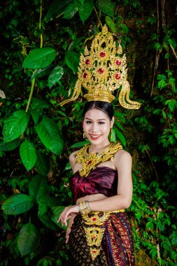 Şelalede eski bir Tayland elbisesi giymiş bir kadın..