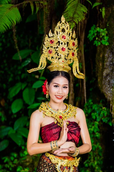 A woman dressed with an ancient Thai dress at the waterfall.