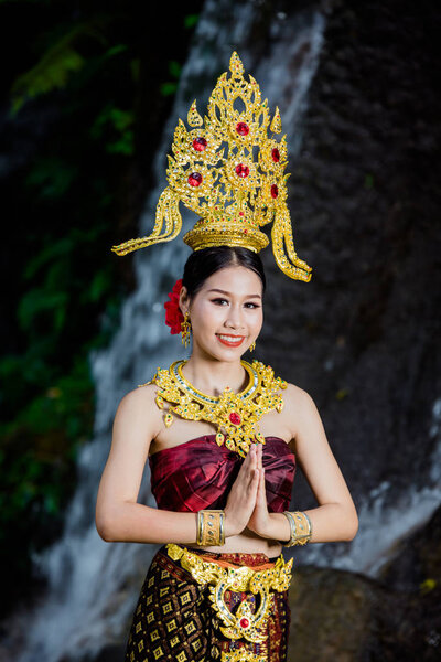 A woman dressed with an ancient Thai dress at the waterfall.