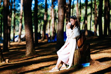 Dişi turistler sabahları ağacın altında kahve içiyor..