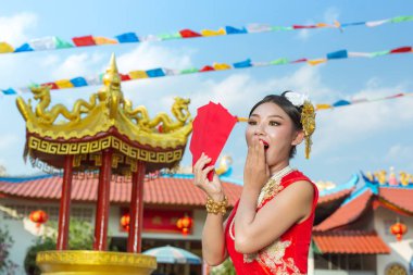 Elinde kağıt yelpaze tutan ve gülümseyen Asyalı güzel bir kız onu mutlu gösteriyor..