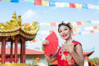 Elinde kağıt yelpaze tutan ve gülümseyen Asyalı güzel bir kız onu mutlu gösteriyor..