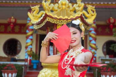 Elinde kağıt yelpaze tutan ve gülümseyen Asyalı güzel bir kız onu mutlu gösteriyor..