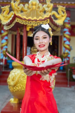 Elinde kağıt yelpaze tutan ve gülümseyen Asyalı güzel bir kız onu mutlu gösteriyor..