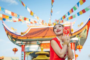 Elinde kağıt yelpaze tutan ve gülümseyen Asyalı güzel bir kız onu mutlu gösteriyor..