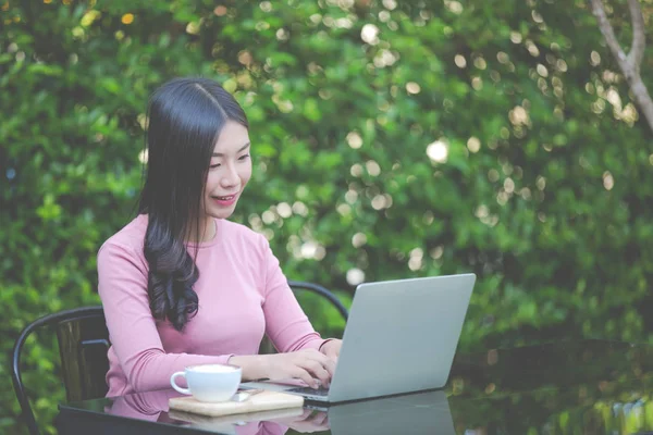 Women are selling products through social media using online notebooks at coffee shops.