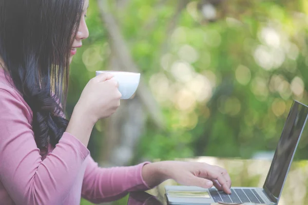 Women are selling products through social media using online notebooks at coffee shops.