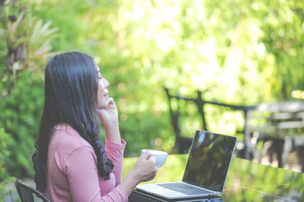 Women are selling products through social media using online notebooks at coffee shops.