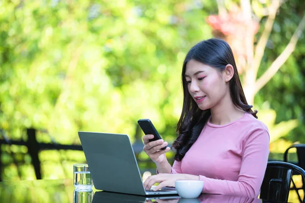 Women are selling products through social media using online notebooks at coffee shops.