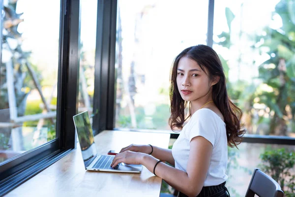 Women are selling products through social media using online notebooks at coffee shops.