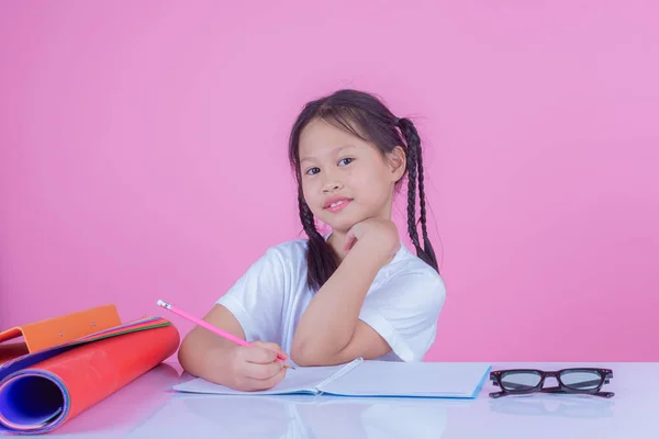 Girls write books on a pink background.