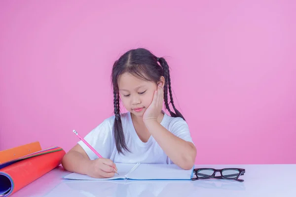 Girls write books on a pink background.