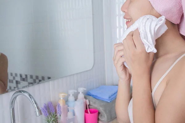 Asian girl washes face.