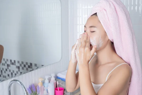 Asian girl washes face.