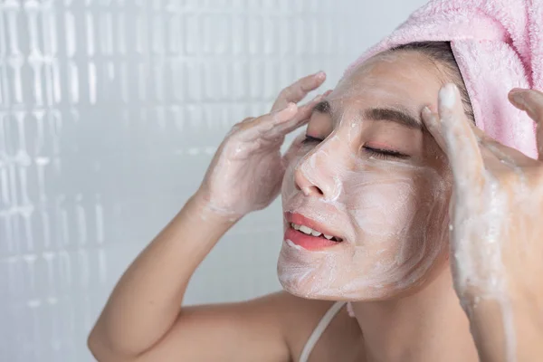 Asian girl washes face.