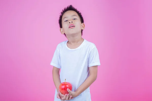 Boy Holds Eats Red Apples Pink Background — Stockfoto