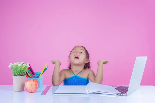 Girls children write book gestures on a pink background.