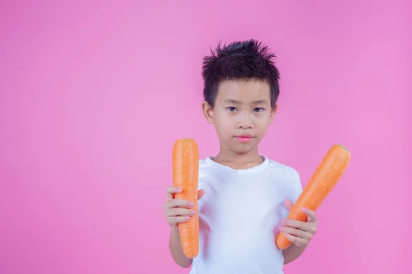 Boy Holding Carrot Pink Background — Stockfoto