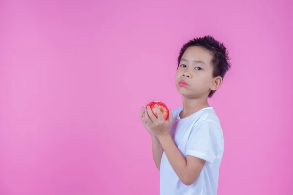 Boy Holds Eats Red Apples Pink Background — Stockfoto