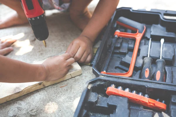 Boy child holding hand tools electric screwdriver.