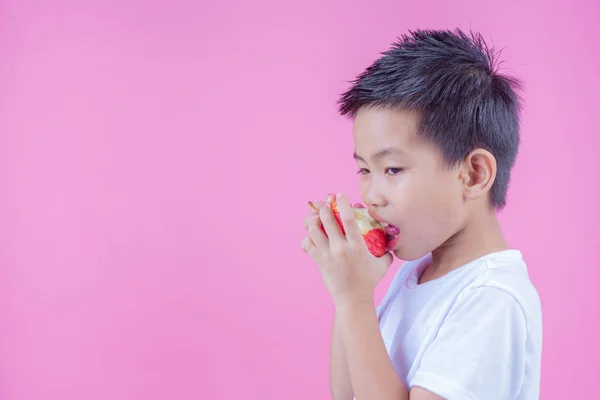 Boy Holds Eats Red Apples Pink Background — Stockfoto