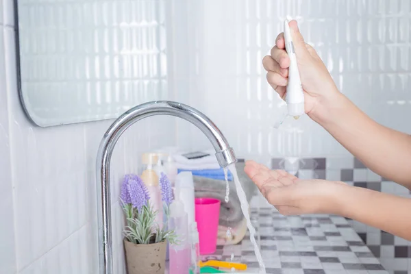 Asian girl washes face.