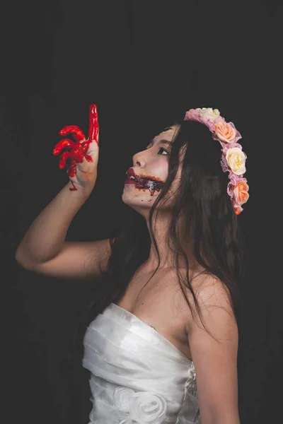 Een vrouwelijke geest of een zombie die een witte jurk met bloederige Han draagt — Stockfoto