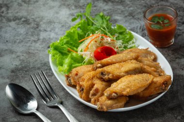 Balık soslu kızarmış kanatlar, güzel süslenmiş otlar ve servis edilen.