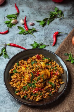 Tayland yemeği malzemeleriyle süslenmiş fesleğen yapraklı kızarmış domuz eti. 